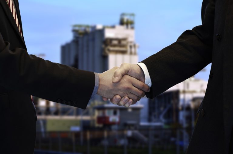 Business Consulting and Technology Solutions - shaking hands; deal closed.