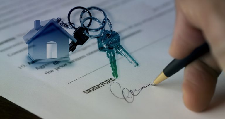 Expert real estate solutions to close deals. Lease signed with keys on the lease.